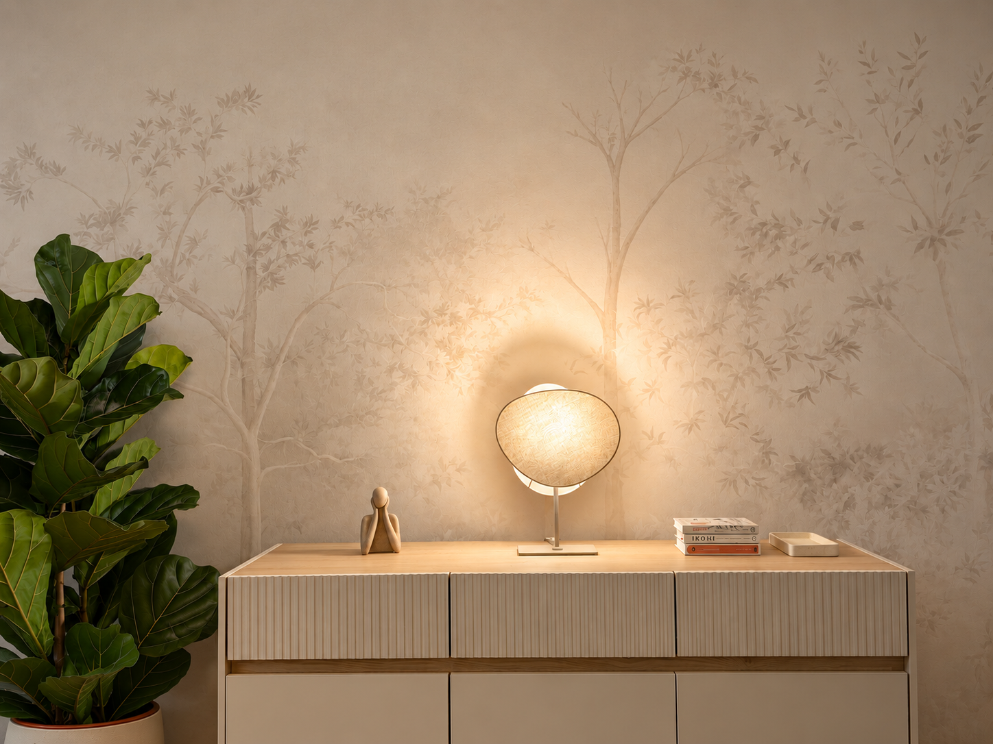 Fikus, osvijetljena lampa i komoda uz neutralnu tapetu u HypnoHausu